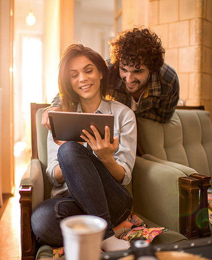 Young couple looking at tablet in living room