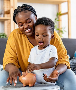 Mother and son putting coin in piggy bank
