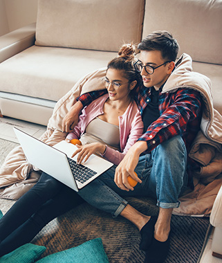 Young couple looking at laptop in living room