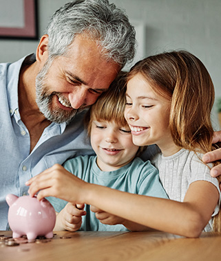 Man with two kids putting coins in a piggy bank