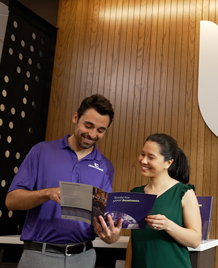 Two people having a conversation in a bank branch lobby